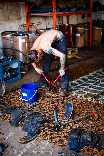 Worker repairing a scallop drag, or net, Lunenburg, Nova Scotia